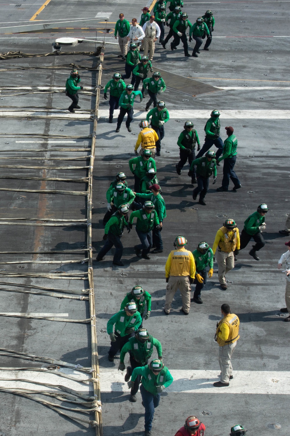 U.S. Sailors run back to their stations during a barricade drill