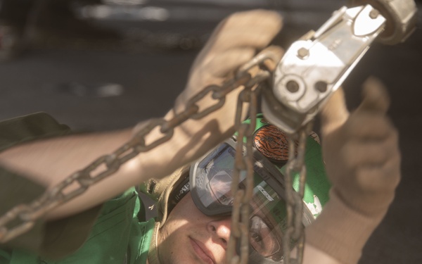 Marine tightens a chain on a Sea Stallion
