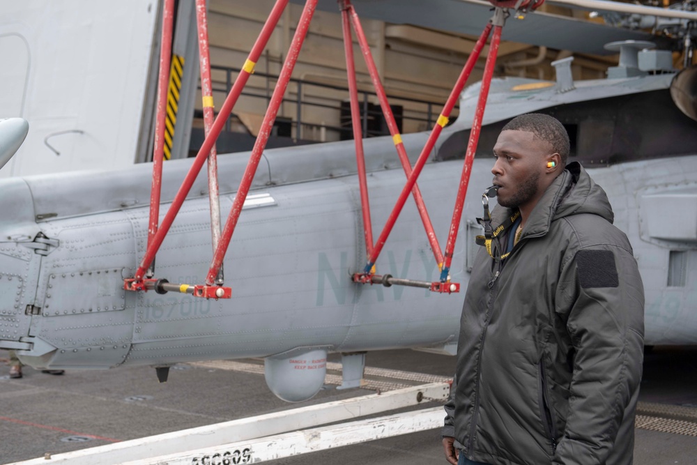 Sailor directs a helicopter on the flight deck Aboard USS Somerset