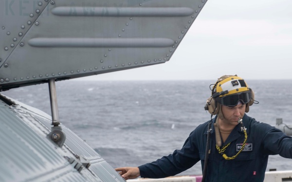 Sailor directs a helicopter on the flight deck Aboard USS Somerset