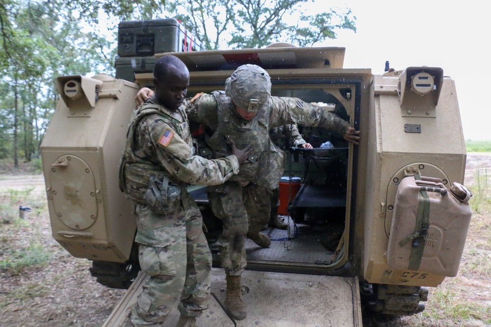 Combat medics extract a casualty from an M113 armored personnel carrier
