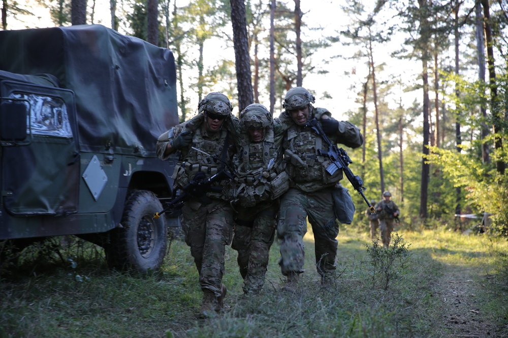 U.S. Soldiers assist a colleague during Saber Junction 19