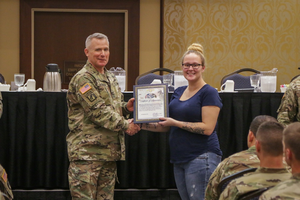 Specialist Kristen Thweatt is presented a Certificate of Appreciation by Lieutenant General Paul J. LaCamera, Commanding General of XVIII Airborne Corps and Fort Bragg