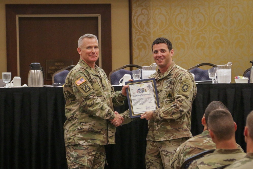 Master Sergeant Joshua Brown is presented a Certificate of Appreciation by Lieutenant General Paul J. LaCamera, Commanding General of XVIII Airborne Corps and Fort Bragg