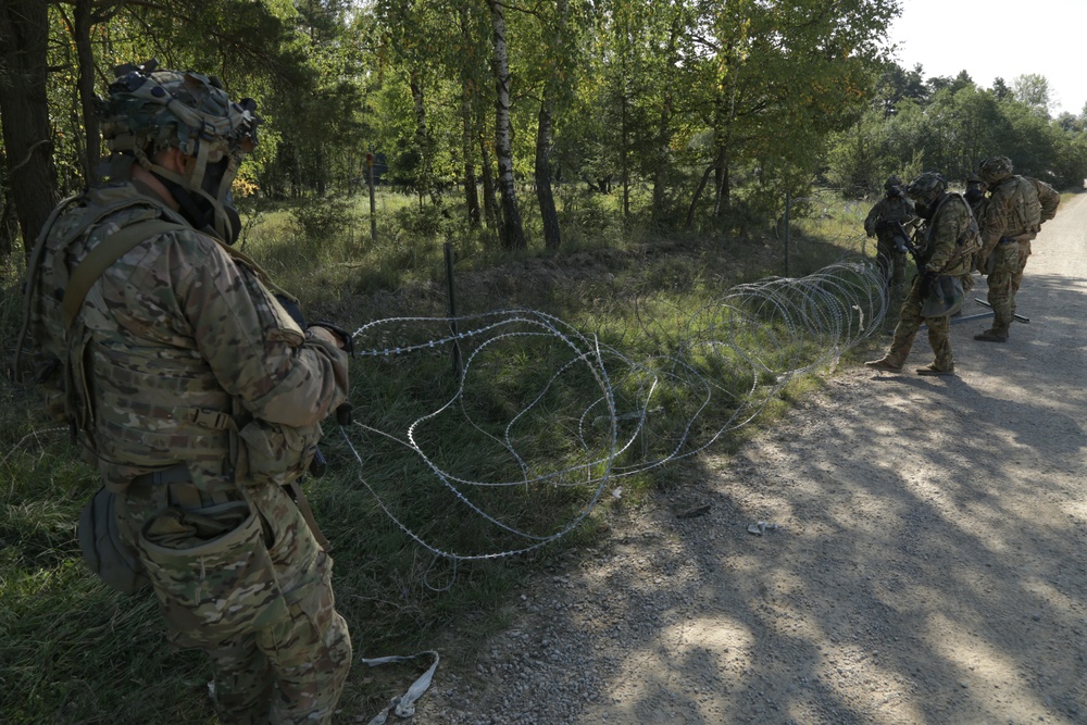 U.S. Soldiers build concertina wire obstacles during Saber Junction 19