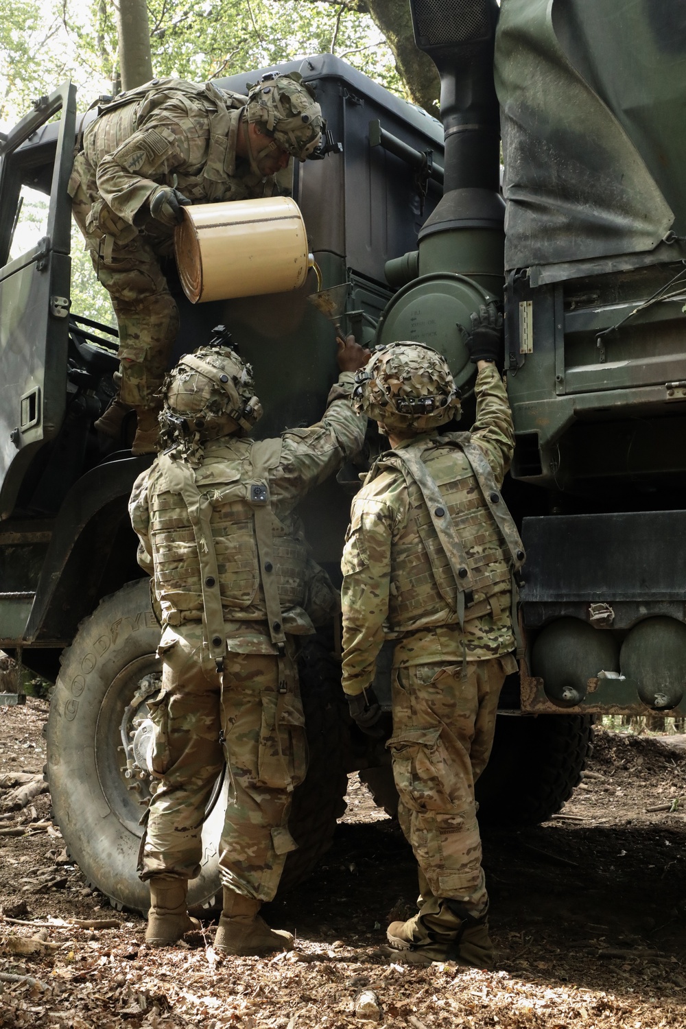 U.S. Soldiers fill oil into a M984A4 recovery truck during Saber Junction 19