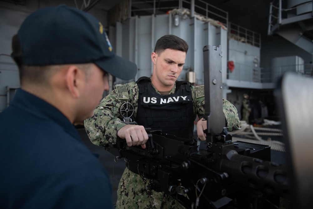 U.S. Navy Sailor conducts maintenance on a .50-caliber rifle on the fantail of the aircraft carrier USS John C. Stennis
