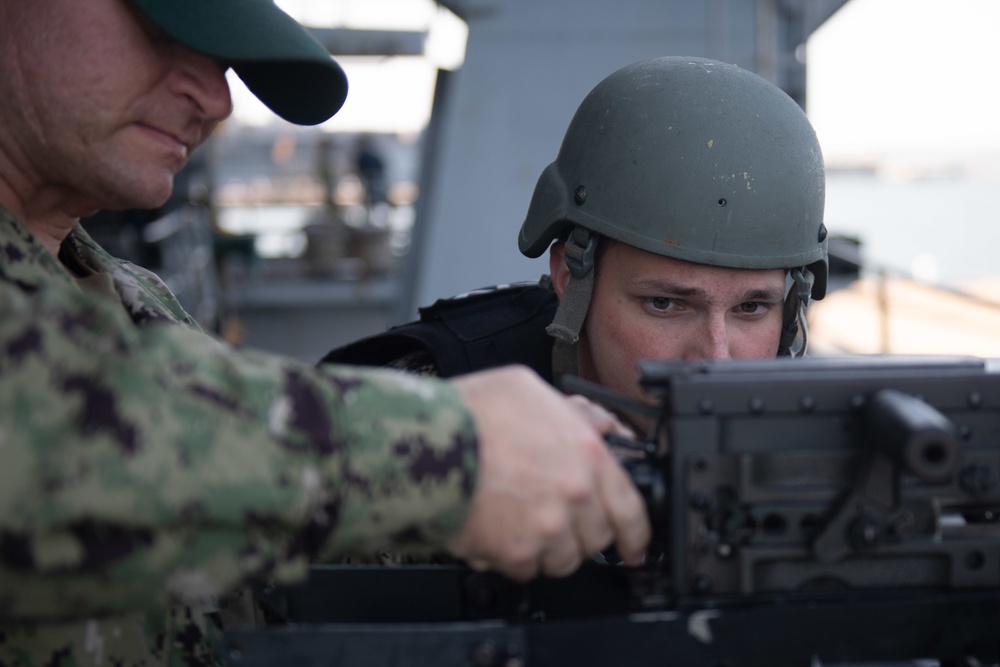 U.S. Navy Aviation Ordnanceman Airman Seth Devine, from Oregon City, Oregon, conducts maintenance on a .50-caliber rifle on the fantail of the aircraft carrier USS John C. Stennis