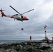 U.S. Coast Guard helicopter lowers rescue basket