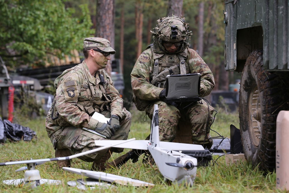 An Observer Coach Trainer interacts with a soldier during Saber Junction 19