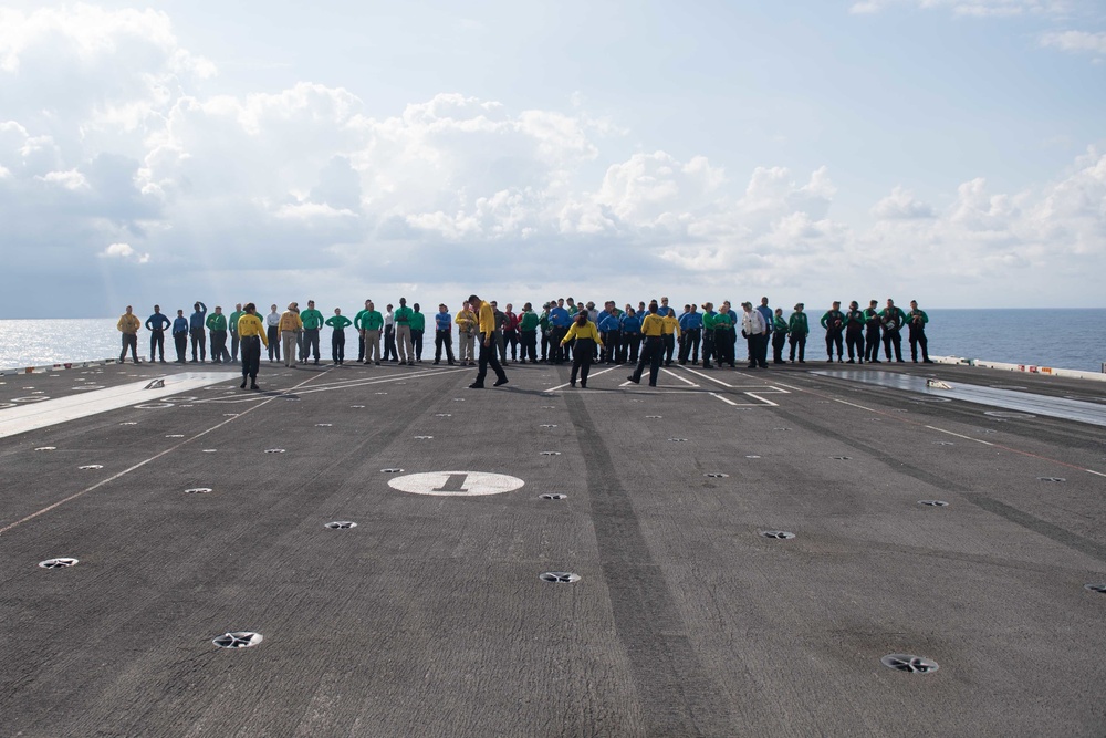 U.S. Sailors participate in a foreign-object-debris walkdown on the flight deck of the aircraft carrier USS John C. Stennis