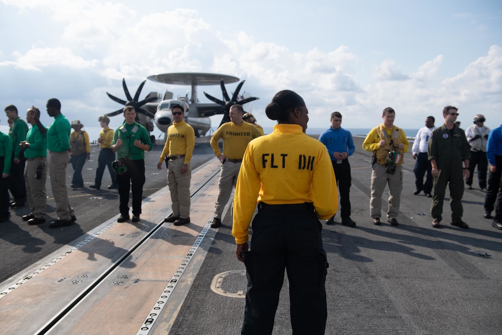 U.S. Sailors participate in a foreign-object-debris walkdown on the flight deck of the aircraft carrier USS John C. Stennis