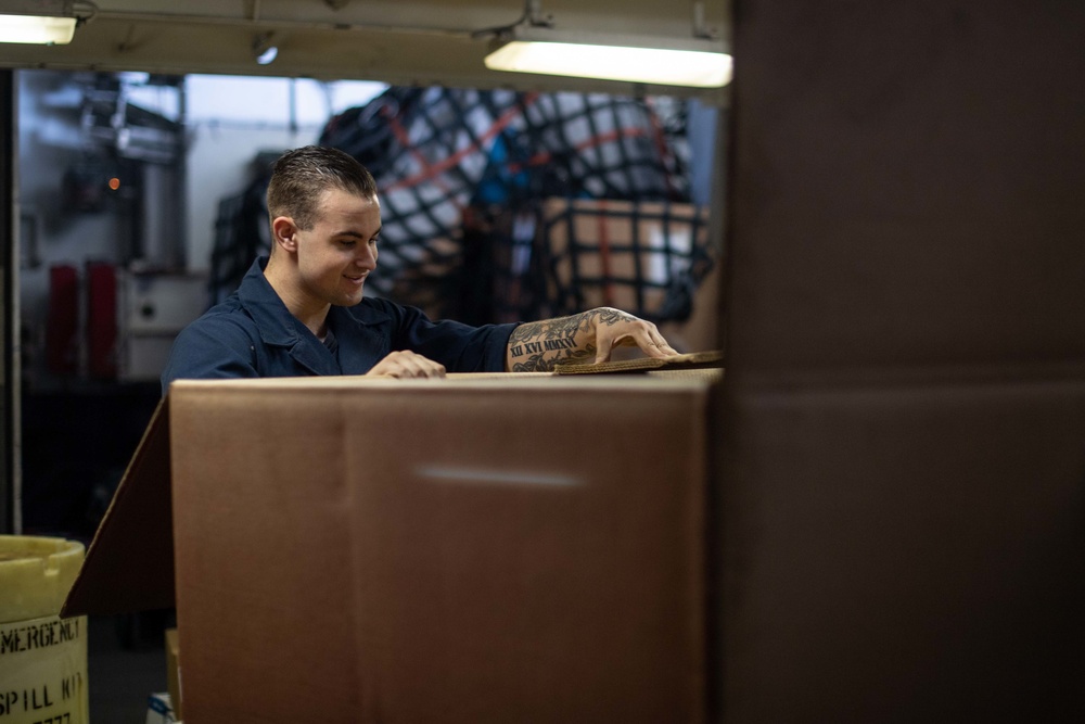 U.S. Sailor folds a box