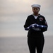 U.S. Navy Religious Programs Specialist 2nd Class Che’lese Bowman, from Clover, Virginia, holds the U.S. flag during a burial at sea
