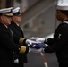 U.S. Navy Religious Programs Specialist 2nd Class Che’lese Bowman, from Clover, Virginia, right, presents Capt. Randy Peck, left, commanding officer of the aircraft carrier USS John C. Stennis (CVN 74), with an American flag during a burial at sea