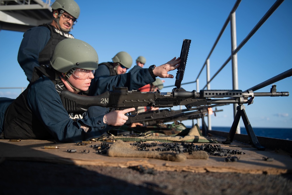 U.S. Navy Master-at-Arms fires an M240B machine gun during a live-fire exercise on the fantail aboard the aircraft carrier USS John C. Stennis
