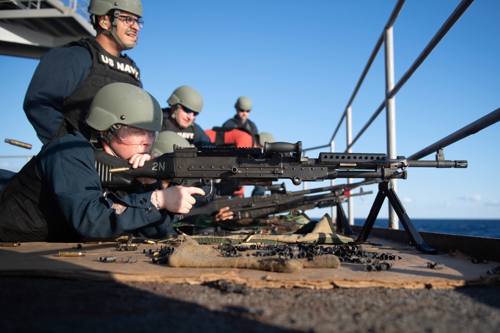 U.S. Navy Master-at-Arms from Sturgeon Bay, Wisconsin, fires an M240B machine gun during a live-fire exercise on the fantail aboard the aircraft carrier USS John C. Stennis