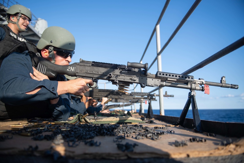 U.S. Navy Gunner’s Mate fires an M240B machine gun during a live-fire exercise on the fantail aboard the aircraft carrier USS John C. Stennis