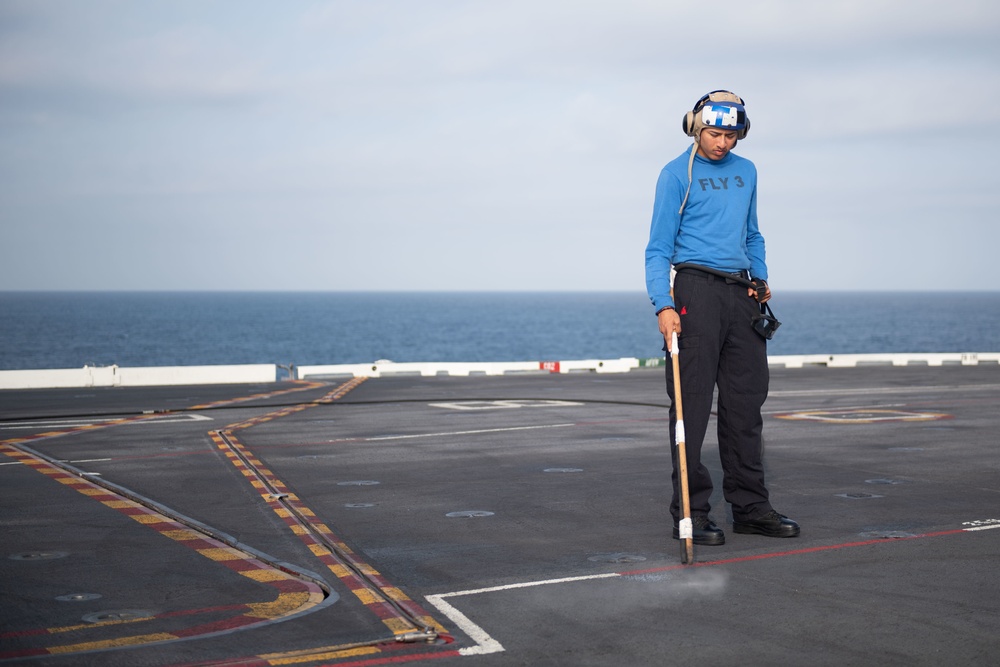 U.S. Sailor cleans pad-eyes on the flight deck of the aircraft carrier USS John C. Stennis