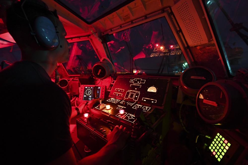 Helicopter Maritime Strike Squadron 77 (HSM 77) officer assists with landing of a MH-60 Sea Hawk helicopter