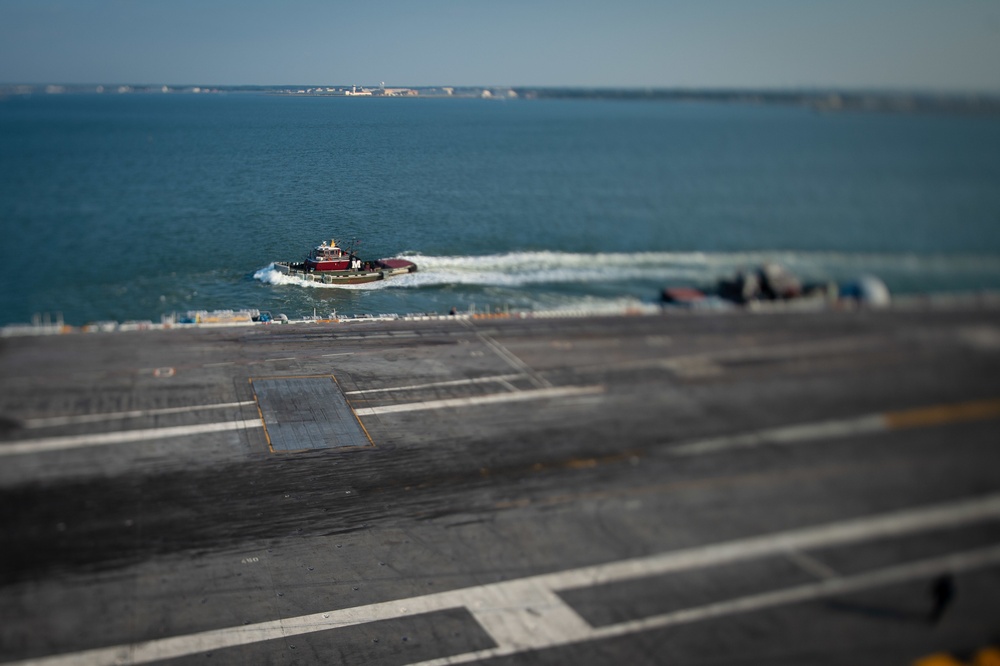 A tug boat comes alongside a U.S. Ship