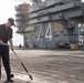 U.S. Sailors cleans padeyes on the flight deck
