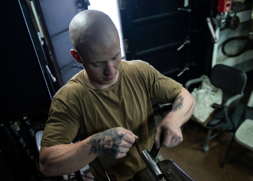 Sailor brazes metal aboard Frank Cable