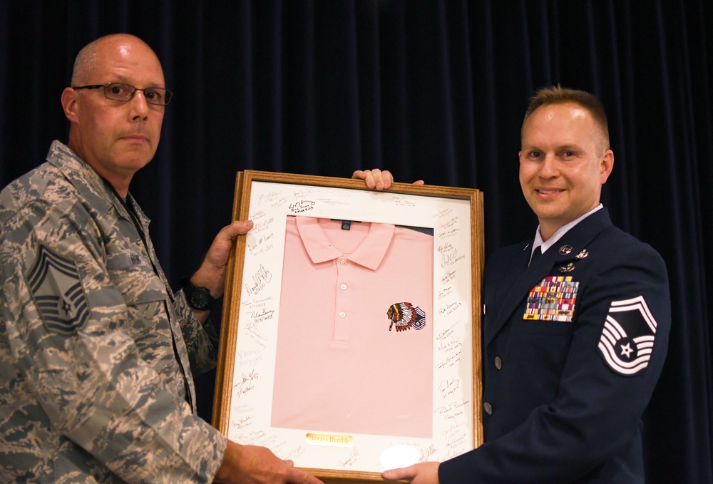 Chief Master Sgt. Terry Hunt hands off the pink polo to Chief Master Sgt. Jeffrey Linton