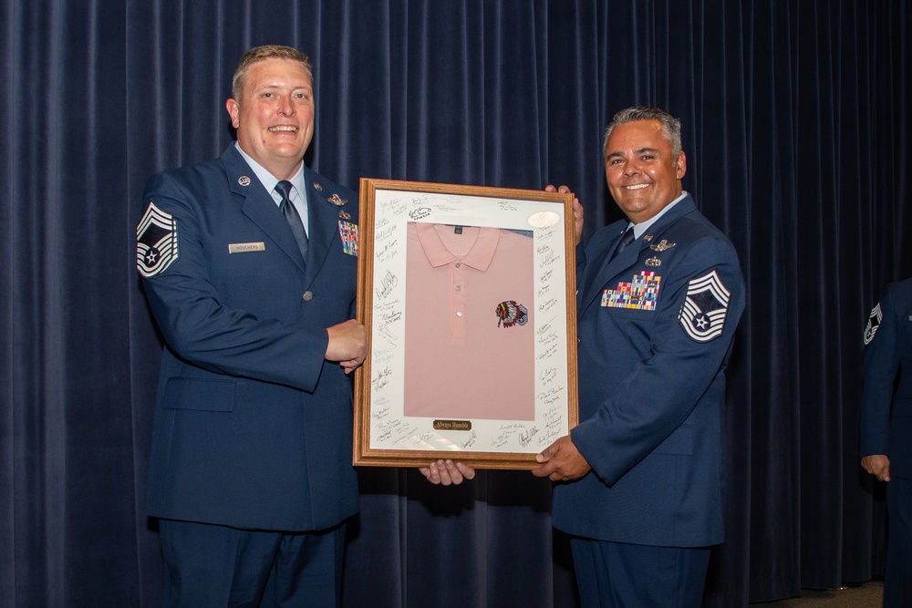 Chief Master Sgt. Todd Houchens hands off the pink polo to Chief Master Sgt. Cameron Pieters