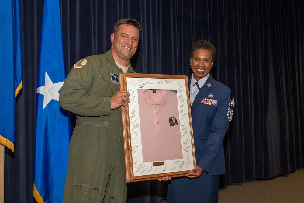 Chief Master Sgt. Shawn Plunket hands off the pink polo to Chief Master Sgt. Angela Ash