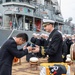 USS Pioneer (MCM 9) commanding officer gives a ball cap to the mayor of Uki city during Pioneer’s arrival ceremony