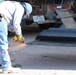 Task Force Barrier contractor prepares a steel bollard barrier panel for placement in Columbus, N.M.