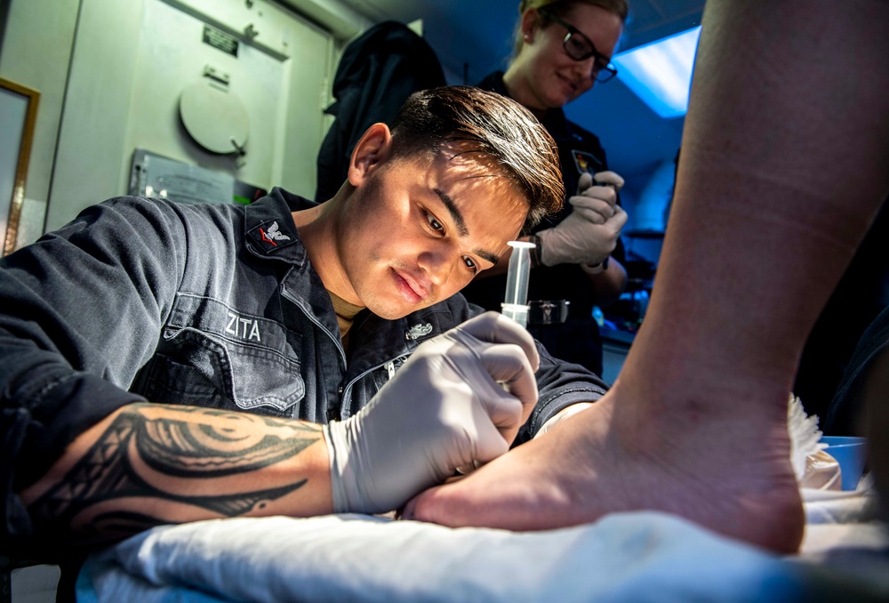 A Sailor Aboard USS Milius (DDG 69) Performs Medical Care