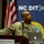 A U.S. Army soldier with the last name 'Griffin' is presenting at a podium during an event hosted by the North Carolina Department of Information Technology (NC DIT). The event is taking place at the McKimmon Conference &amp; Training Center, likely associated with NC State University. The soldier is in military camouflage uniform and appears to be looking upward, possibly at a presentation screen.