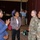 Four individuals are engaged in conversation in what appears to be a conference or event venue. Two civilians (women in business attire) are speaking with two U.S. Army soldiers in camouflage uniforms. The setting suggests a professional networking or briefing event.