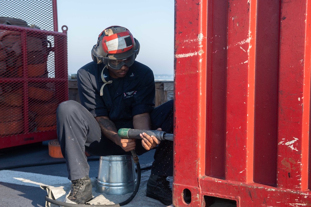 U.S. Navy Sailor performs maintenance on flight deck of USS John C. Stennis