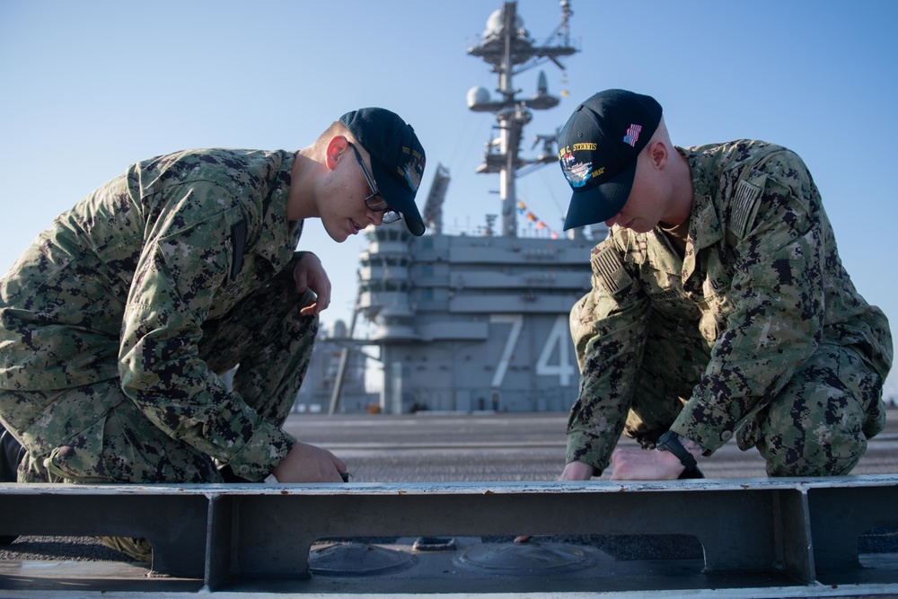 U.S. Navy Sailors perform maintenance on flight deck of USS John C. Stennis