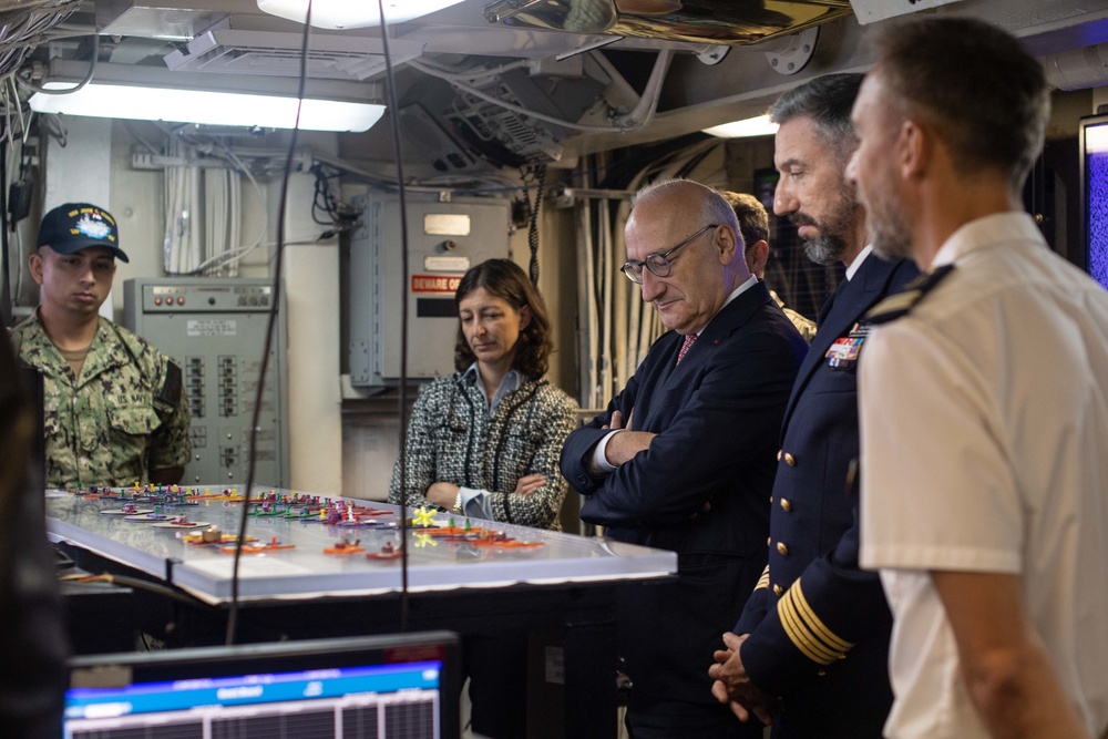 His Excellency Philippe Etienne, center, Ambassador of France to the U.S., observes the flight deck status board in flight deck control