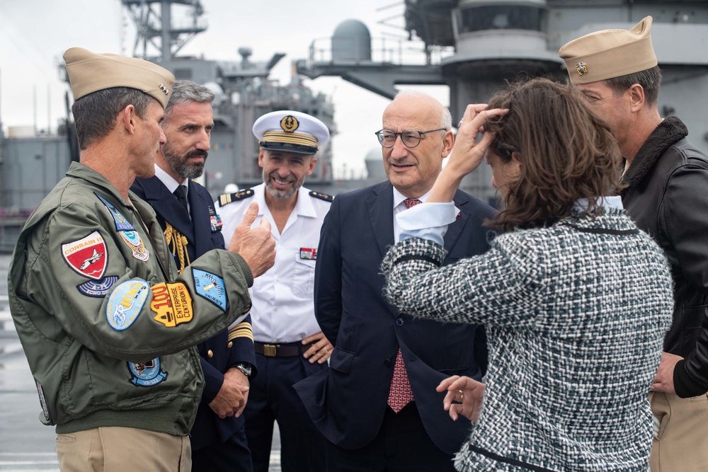 U.S. Navy Vice Adm. Andrew Lewis, left, commander of U.S. 2nd Fleet, speaks with His Excellency Philippe Etienne, center right, Ambassador of France to the U.S., on the flight deck of the aircraft carrier USS John C. Stennis (CVN 74)