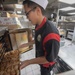 USS McCampbell Sailors prepare meals