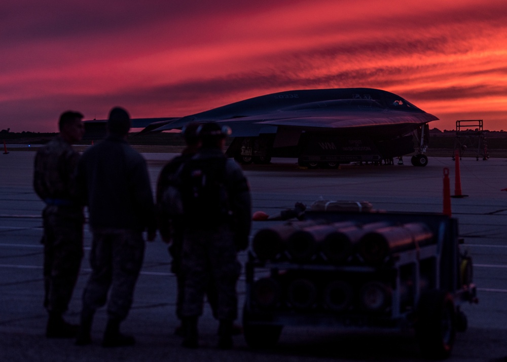 Maintainers assigned from Whiteman watch a sunset near a B-2 Spirit Stealth Bomber