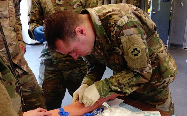 Spc. Jeffrey Theisen administers an IV