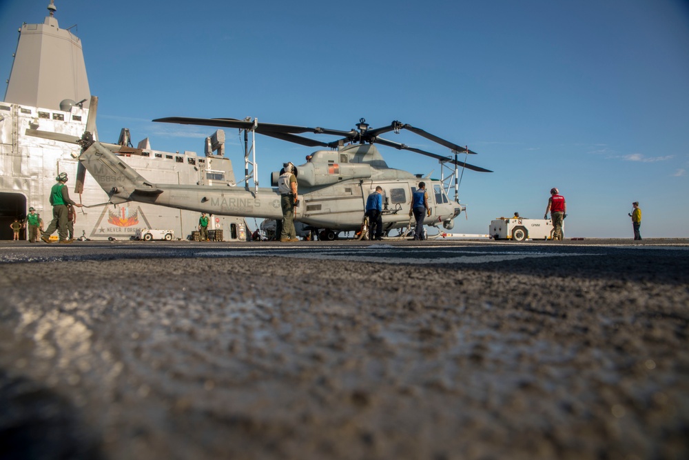 Sailors and Marines move a UH-1Y Huey helicopter