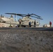 Sailors and Marines move a UH-1Y Huey helicopter