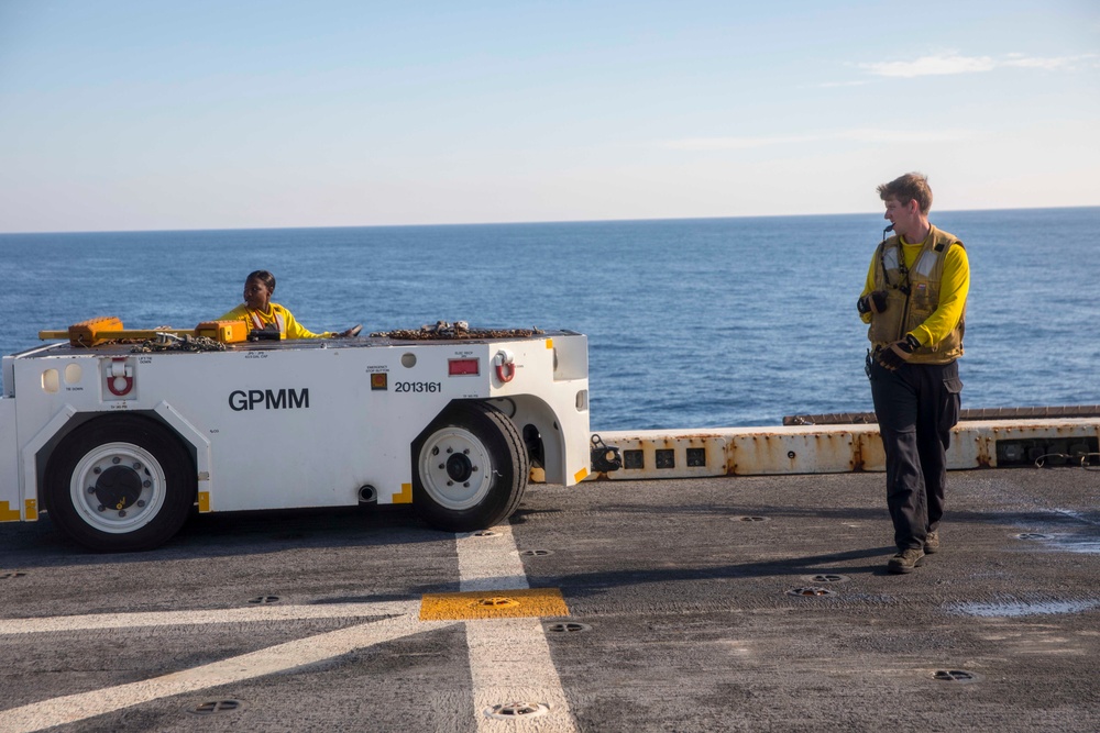 Sailors move a UH-1Y Huey helicopter