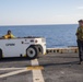 Sailors move a UH-1Y Huey helicopter