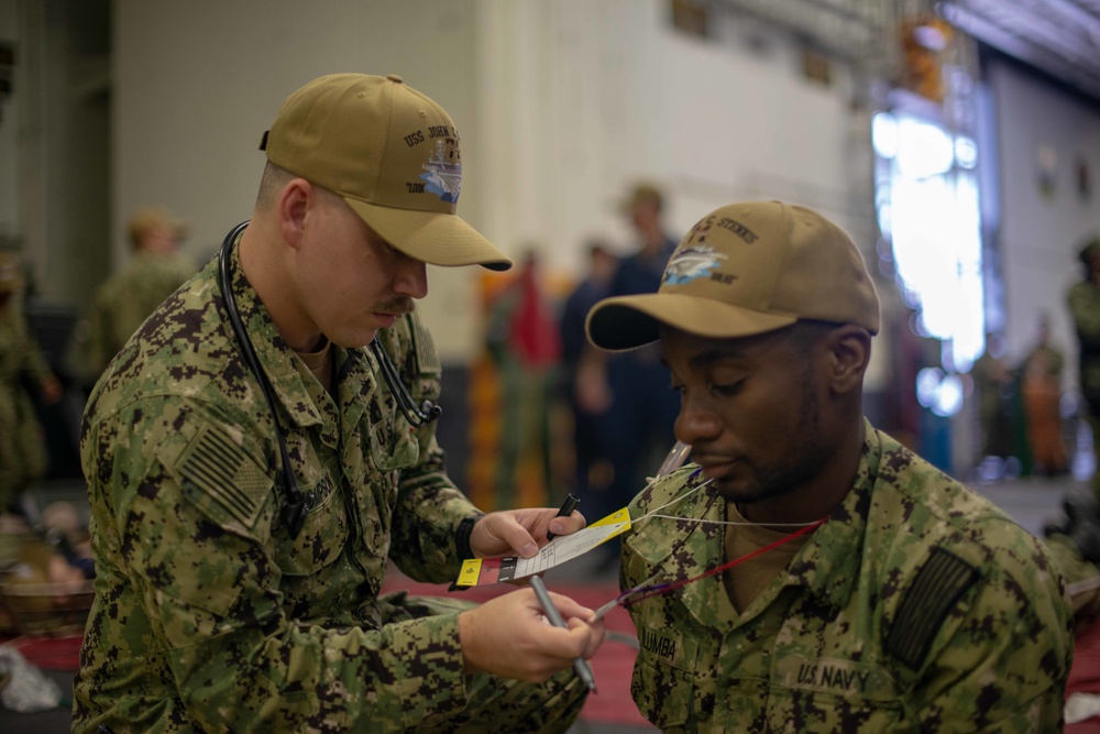 U.S. Navy Hospitalman Bradley Thompson, from Pasco, Washington, checks on a simulated patient during a mass casualty drill