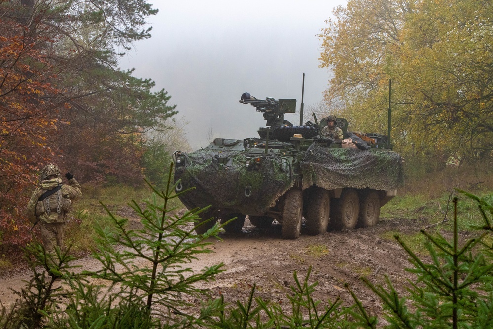 Soldiers prepare to conceal a Stryker 