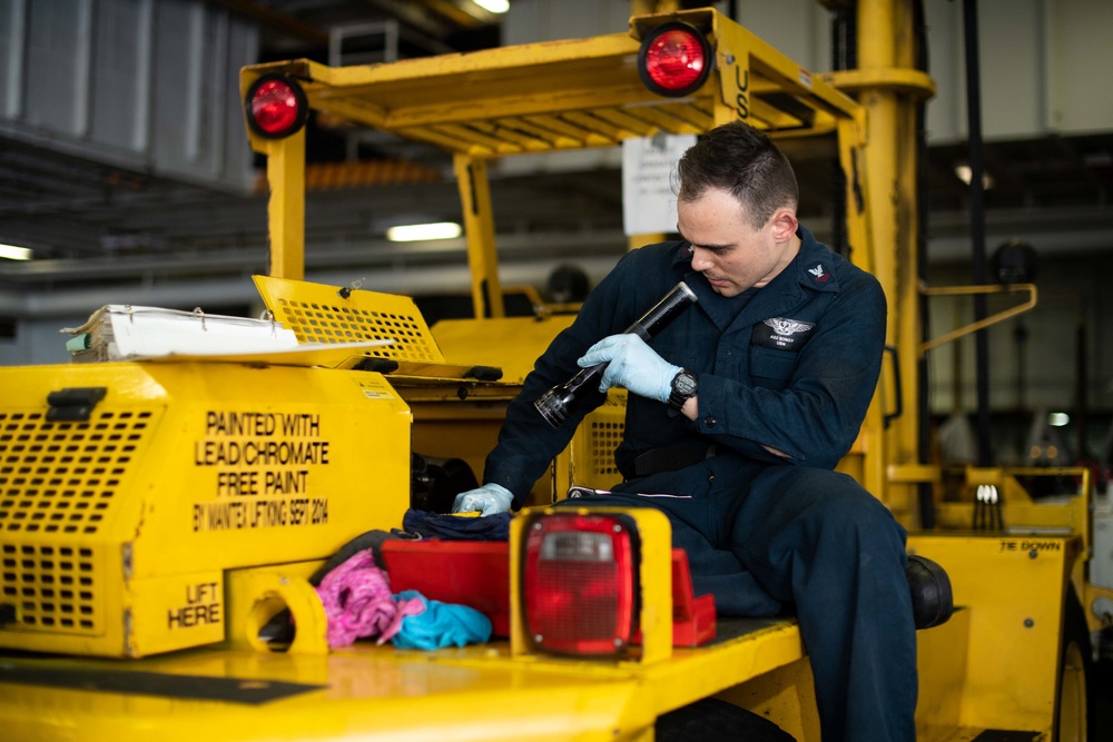 U.S. Sailor inspects a hydraulic pump