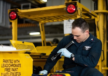 U.S. Sailor inspects a hydraulic pump